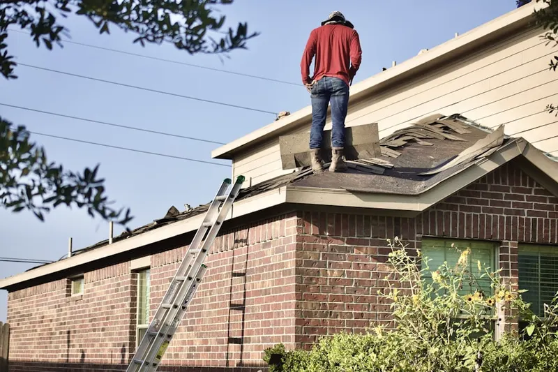 Professional roofer working on a residential roof in Baldwyn